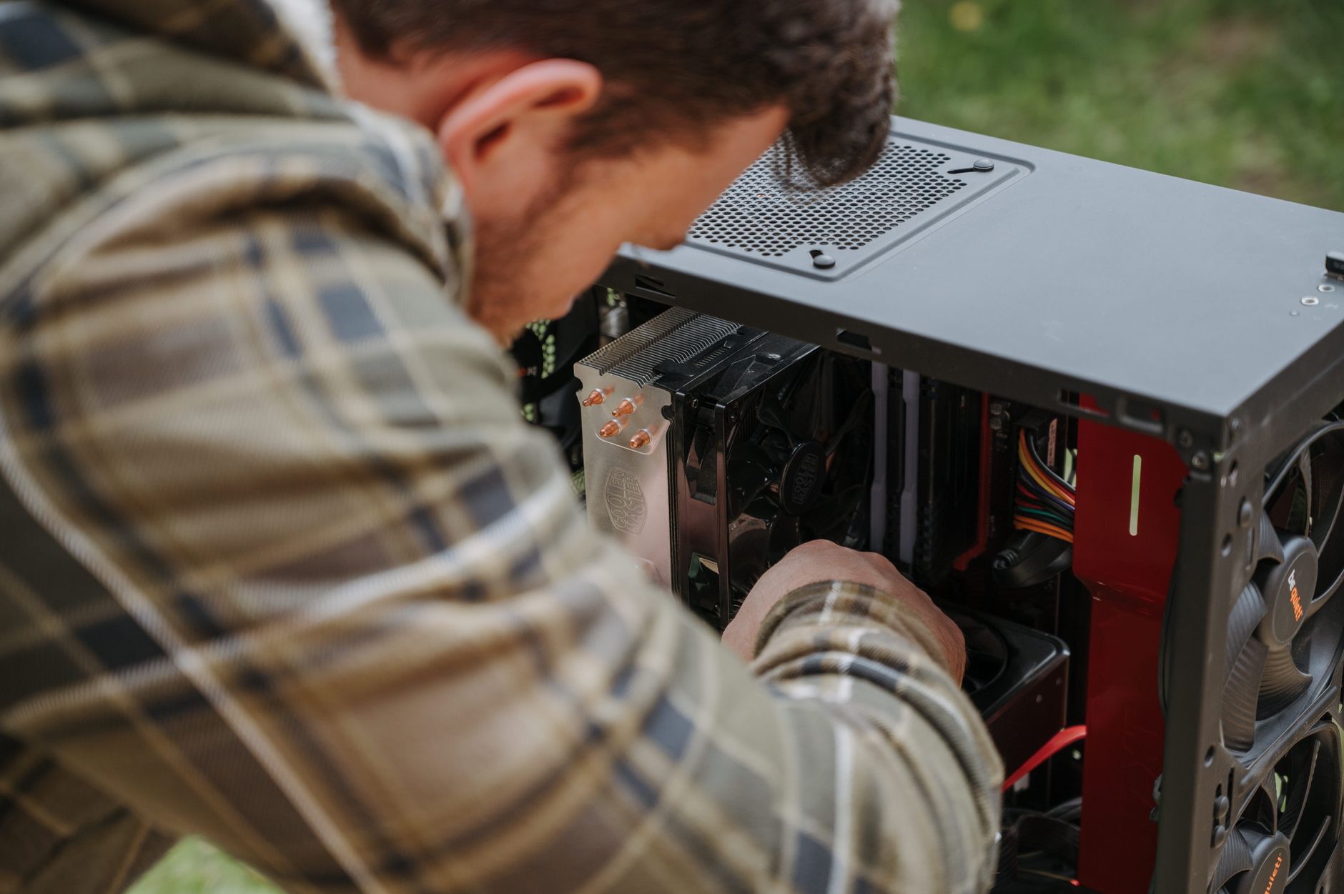 Detailing the technology behind Bitcoin mining A man cleans and maintains a desktop PC outdoors with precision.